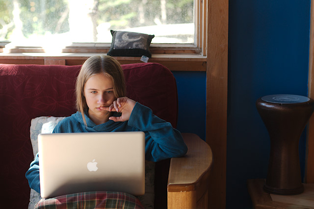 teen girl on couch with computer